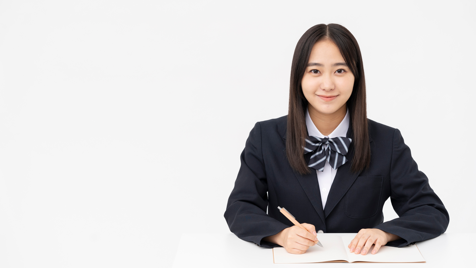制服姿の生徒が机でノートを開き学習に向かう様子