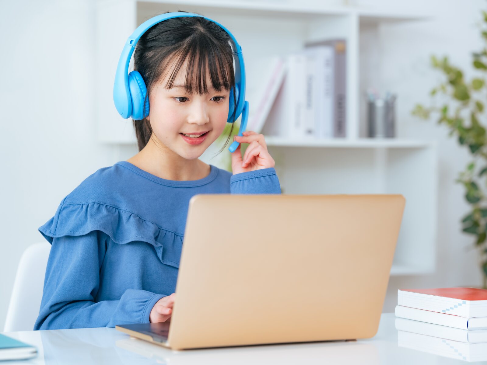 ヘッドセットを着けてノートパソコンでオンライン授業を受ける小学生
